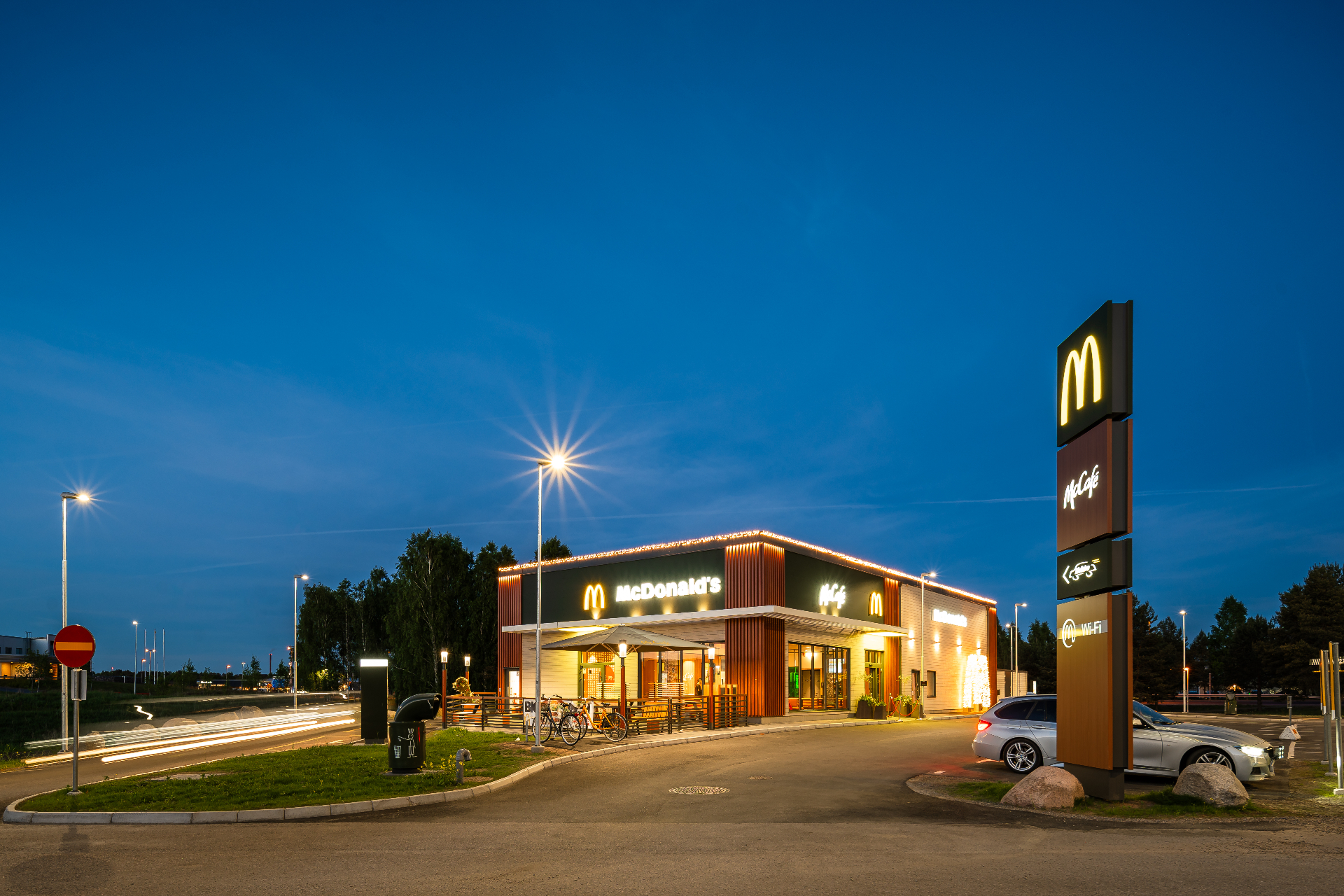 McDonald's Eksjö – översiktsvy med pyloninstallation och ljusspår från förbipasserande bil.