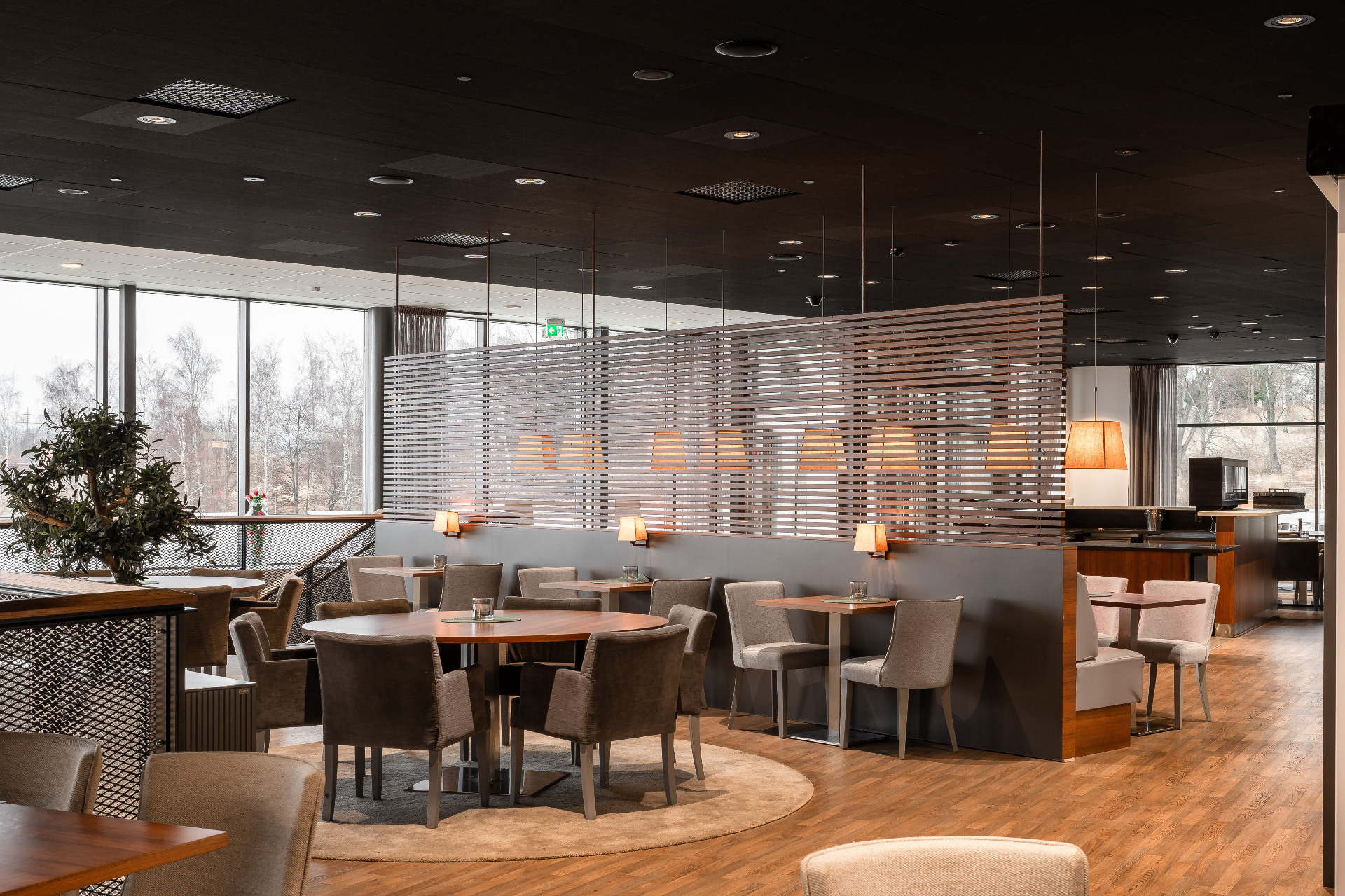 Restaurangmiljö i Jönköping med träinredning, lampor och stora fönster.