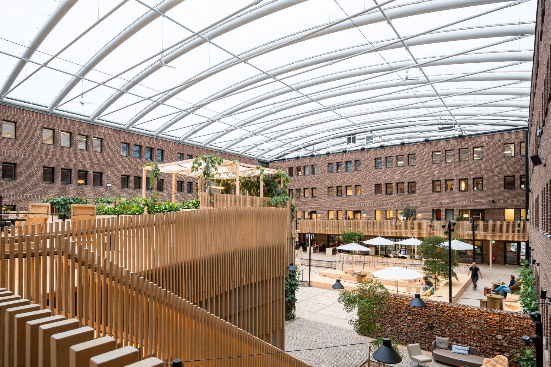 Werket Jönköping – översiktsbild av innergården med spjälade trävolymer och välvt glastak.